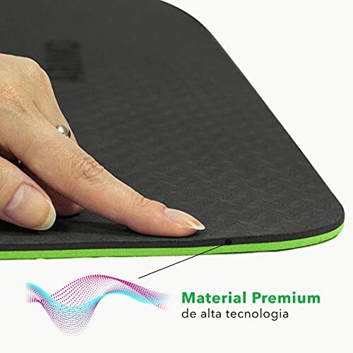 Hand touching edge of a premium black and green mouse pad.